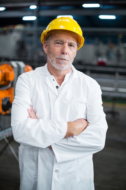 Retrato de ingeniero de fábrica de pie con los brazos cruzados