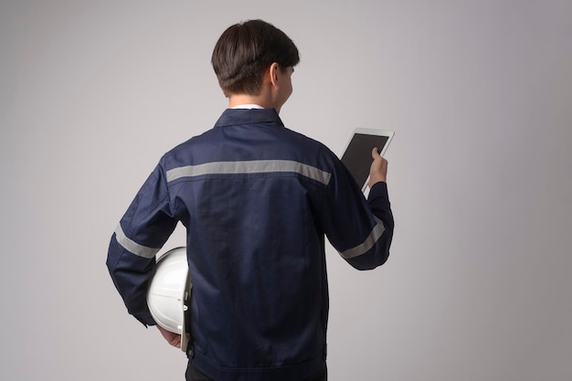 Retrato de un ingeniero que lleva un casco protector sobre un estudio de fondo blanco