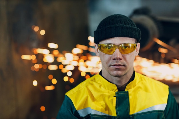 Retrato de un ingeniero trabajador que usa gafas protectoras uniformes en las instalaciones de construcción de metal de la fábrica de acero