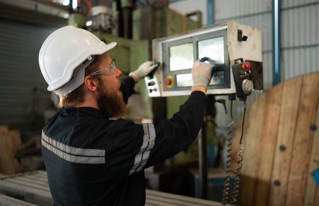 Retrato de ingenieros mecánicos comprobando el estado de funcionamiento de una vieja máquina que se ha utilizado durante algún tiempo en una fábrica donde la luz natural brilla en el lugar de trabajo