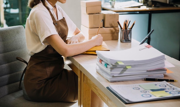 Retrato de inicio de pequeñas empresas Propietarios de pymes Dos mujeres asiáticas revisan pedidos en línea Venta de productos que trabajan con cajas trabajo independiente en la oficina en casa pyme negocio en línea pequeña mediana empresa