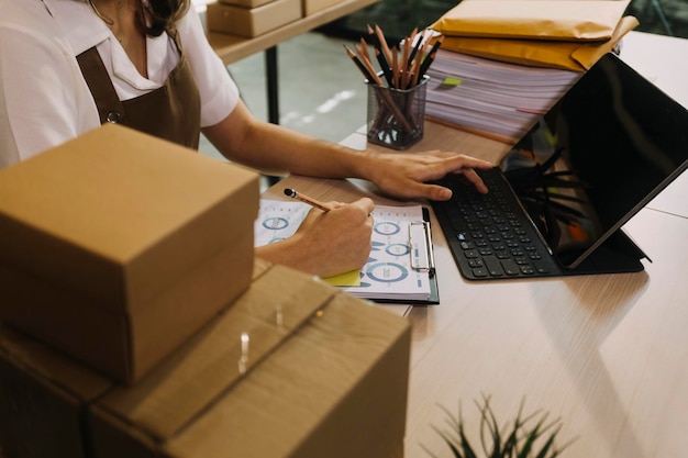 Retrato de inicio de pequeñas empresas Propietarios de pymes Dos mujeres asiáticas revisan pedidos en línea Venta de productos que trabajan con cajas trabajo independiente en la oficina en casa pyme negocio en línea pequeña mediana empresa