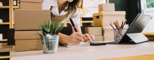 Retrato de inicio de pequeñas empresas Propietarios de pymes Dos mujeres asiáticas revisan pedidos en línea Venta de productos que trabajan con cajas trabajo independiente en la oficina en casa pyme negocio en línea pequeña mediana empresa