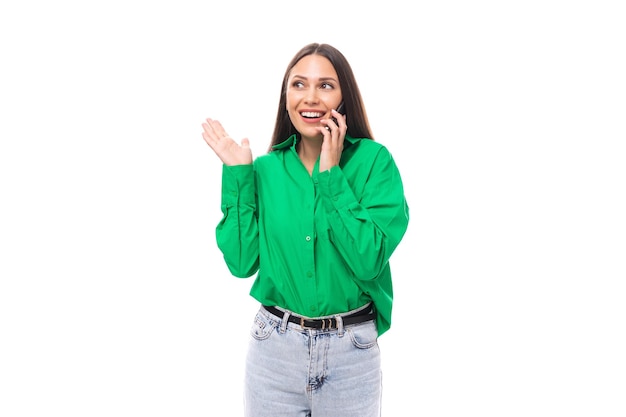 Retrato de una inteligente y pensativa mujer morena de ojos marrones delgada y linda vestida con una camisa verde charlando en