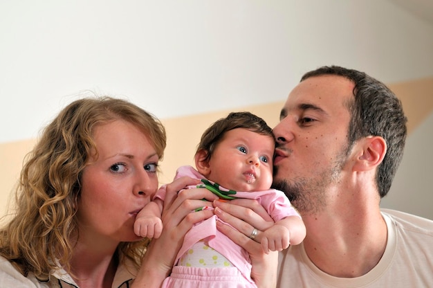 retrato interior con una familia joven feliz y un lindo bebé