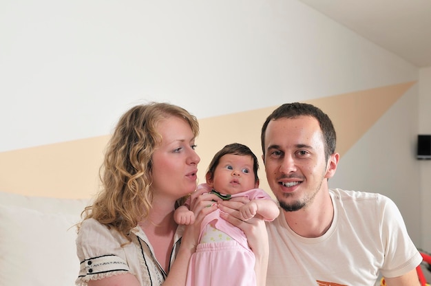 retrato interior con una familia joven feliz y un lindo bebé