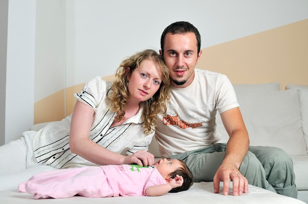 Foto retrato interior con familia joven feliz y pequeño bebé lindo