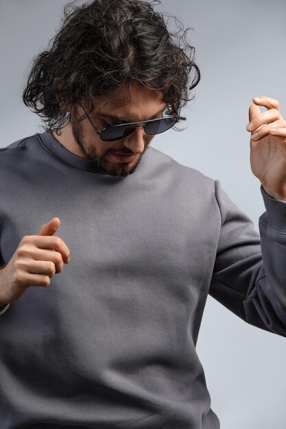 Foto retrato interior de un hermoso hombre sonriente con pecas y cabello rizado que usa gafas septales posando para la sociedad