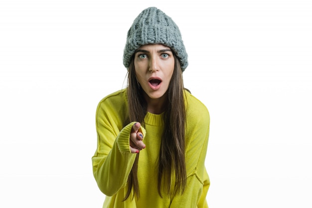 Retrato de invierno de una chica emocional en suéter amarillo y una gorra tejida