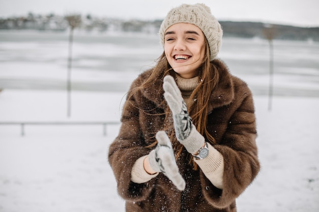 Retrato de invierno de hermosa mujer sonriente con copos de nieve