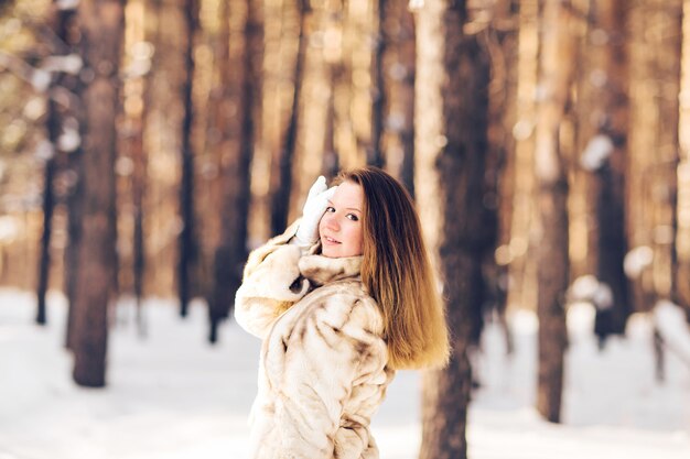 Retrato de invierno de joven bella mujer con abrigo de piel. Concepto de moda de belleza de invierno de nieve.