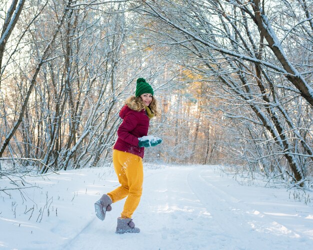 Retrato de invierno de joven hermosa mujer morena en bosque de nieve