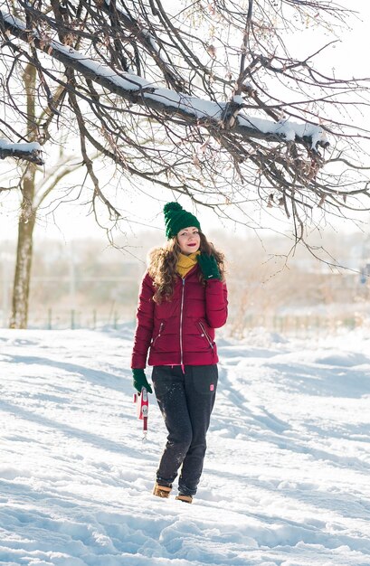 Retrato de invierno de joven hermosa mujer morena con redecilla amarilla en la nieve