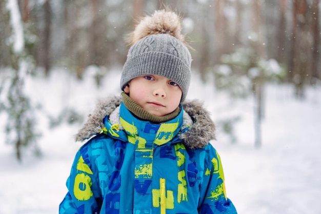 Retrato de invierno de un lindo niño caucásico en un día soleado