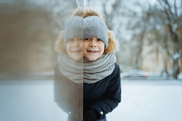 Retrato de invierno de un lindo niño caucásico de edad elemental con sombrero de punto con pompón en la ciudad