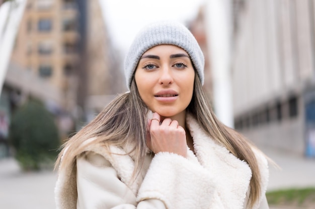 Retrato de invierno de una mujer caucásica con un gorro de lana en la ciudad muy fría