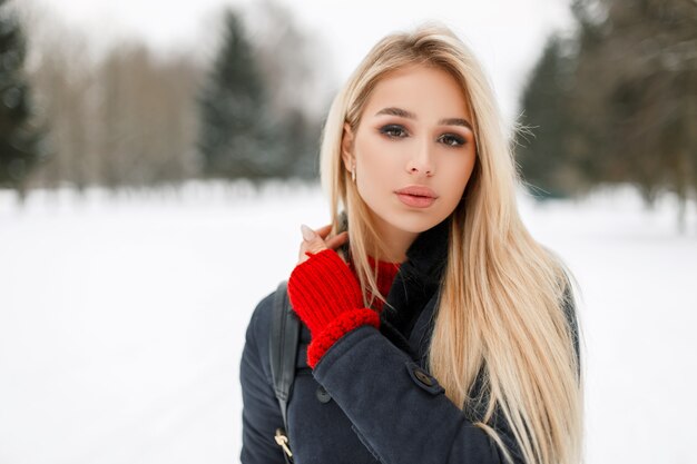 Retrato de invierno de una mujer hermosa modelo glamour en un abrigo de moda al aire libre