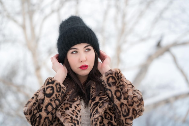 Retrato de invierno de mujer joven con cabello largo y labios carnosos rojos pensativo mirando hacia otro lado