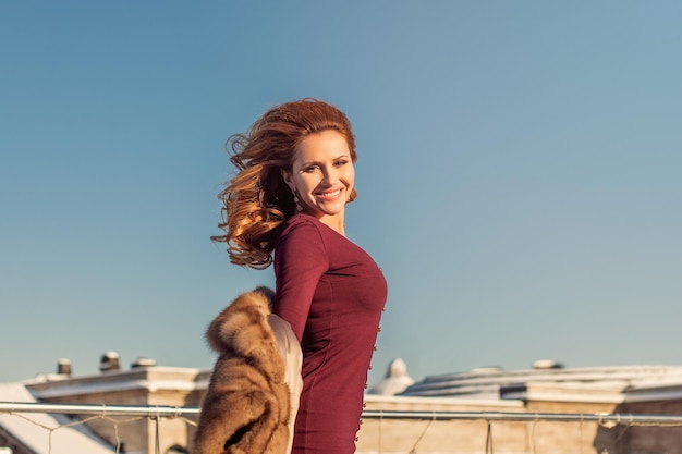 Retrato de invierno de mujer linda con cabello de jengibre rojo contra winte