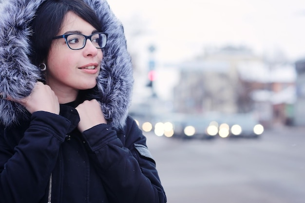 retrato de invierno nevado de una chica en la ciudad en la carretera