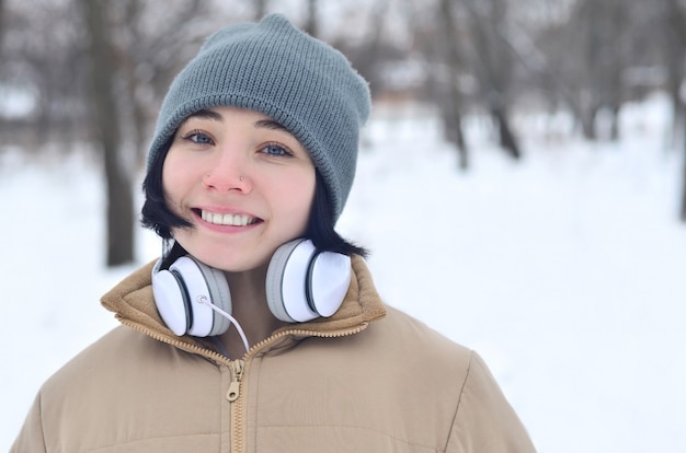 Retrato de invierno de niña con auriculares