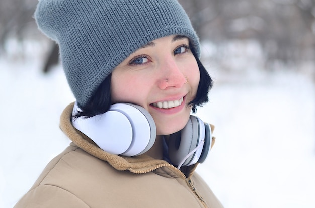 Retrato de invierno de niña con auriculares