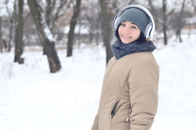 Retrato de invierno de niña con auriculares