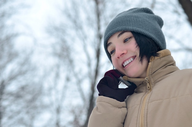 Retrato de invierno de niña con smartphone