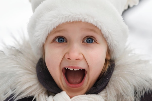 Retrato de invierno niños emociones alegres feliz invierno alegría niño con sombrero blanco es feliz en invierno