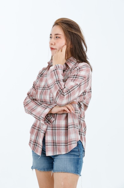 Retrato isolado recorte de estúdio de corpo inteiro modelo feminino alegre e feliz asiático em camisa xadrez casual de mangas compridas shorts jeans e chinelos em pé de braços cruzados sorrindo posando em fundo branco