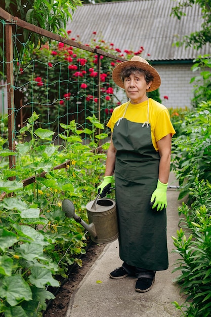 Retrato de una jardinera mayor con sombrero trabajando en su jardín El concepto de jardinería creciendo y cuidando flores y plantas