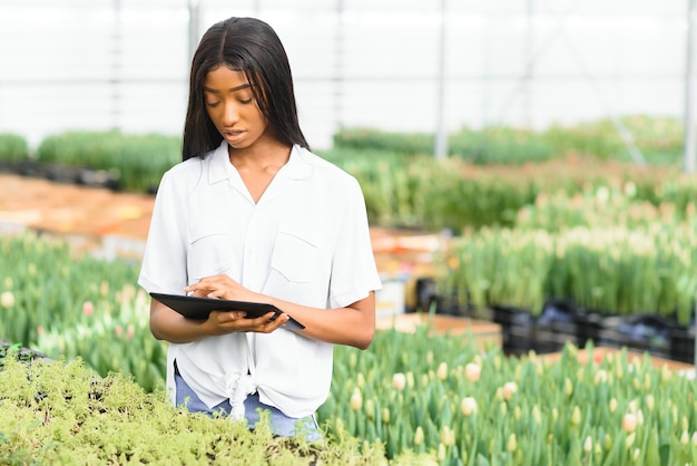 Retrato de jardinero africano bastante joven en invernadero