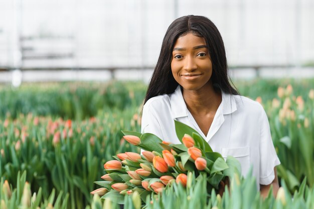 Retrato de jardinero africano bastante joven en invernadero