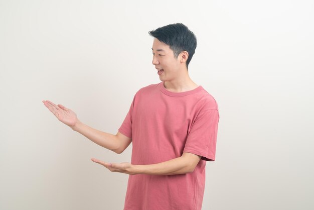 retrato jovem asiático com a mão apontando ou apresentando em fundo branco