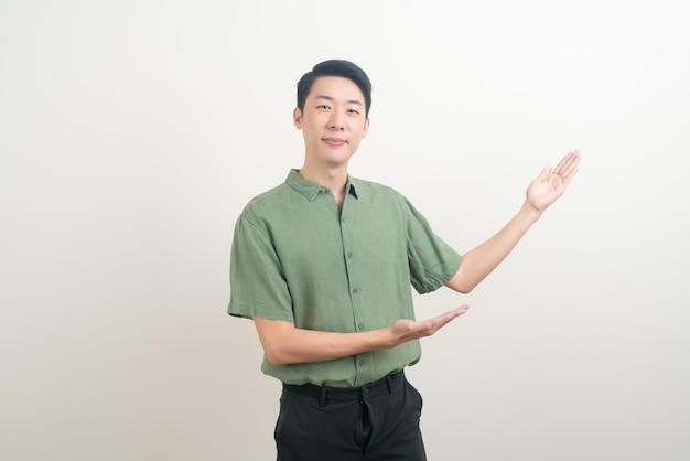 retrato jovem asiático com a mão apontando ou apresentando em fundo branco