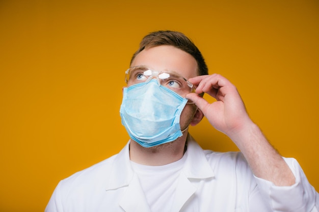 Retrato jovem médico exausto com máscara médica azul no rosto