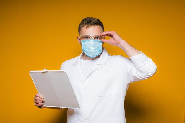 Retrato jovem médico exausto com máscara médica azul no rosto