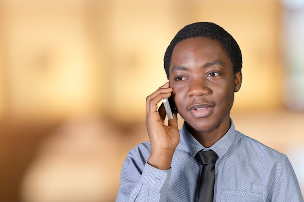 Retrato de un joven africano feliz con un teléfono móvil