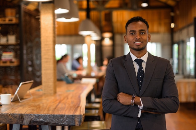 Retrato, de, joven, africano, hombre de negocios, relajante, dentro, cafetería