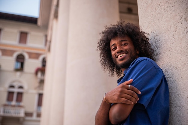 Retrato de un joven africano sonriente con una foto afro de debajo de una persona feliz