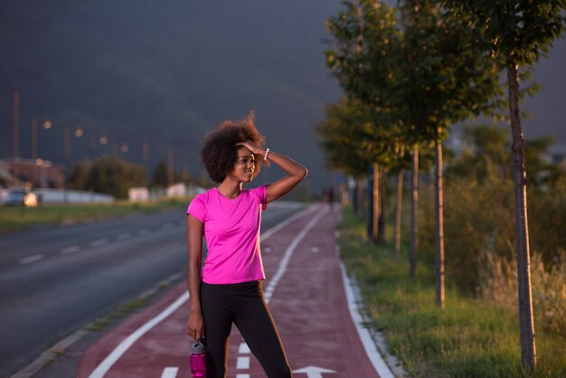 retrato de una joven afroamericana para correr una hermosa tarde de verano en las calles de la ciudad