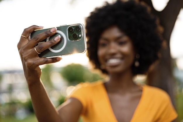 Retrato de una joven afroamericana tomando un selfie al aire libre