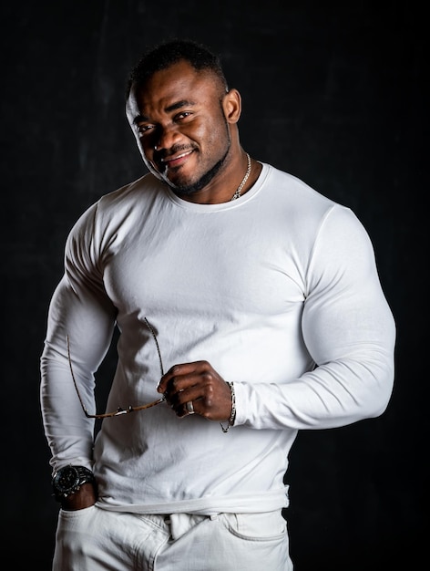 Retrato de un joven afroamericano sonriendo sobre fondo gris