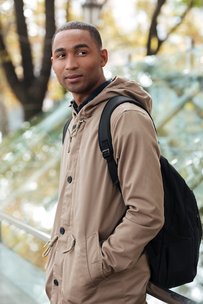 Retrato de un joven alegre caminando por la calle