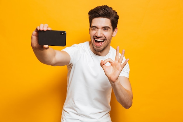 Retrato de un joven alegre tomando un sefie