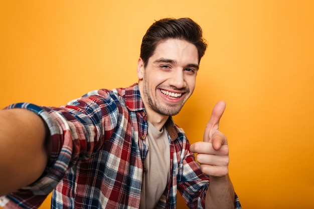 Retrato de un joven alegre tomando una selfie