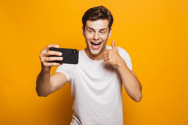 Retrato de un joven alegre tomando un selfie