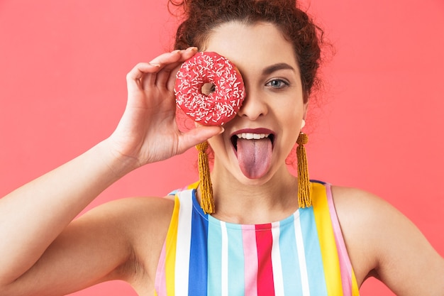 Retrato de una joven alegre vistiendo un vestido que se encuentran aisladas sobre fondo rojo,