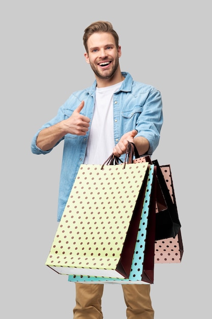 Retrato de un joven apuesto con bolsas de la compra.