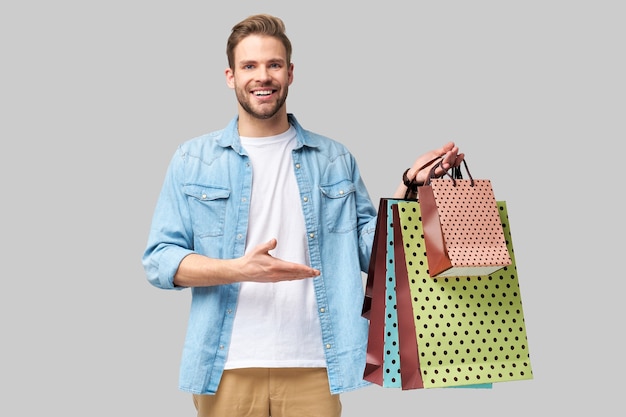 Retrato de un joven apuesto con bolsas de la compra.